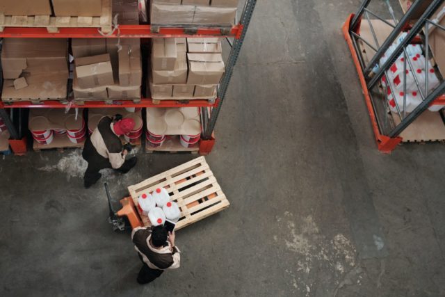 Two workers conducting picking activities in a warehouse.